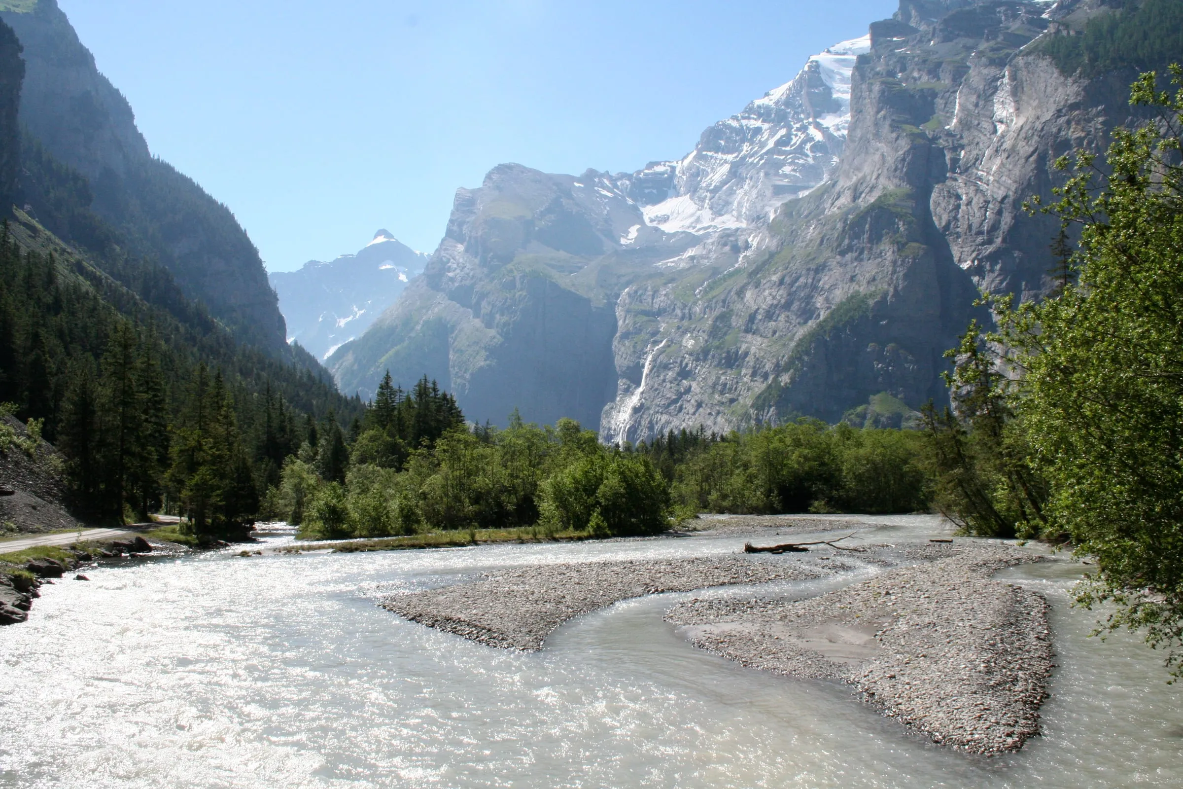Die Kander fliesst über Kiesbänke am Eingang zum Gasterntal, dahinter steile Felswände